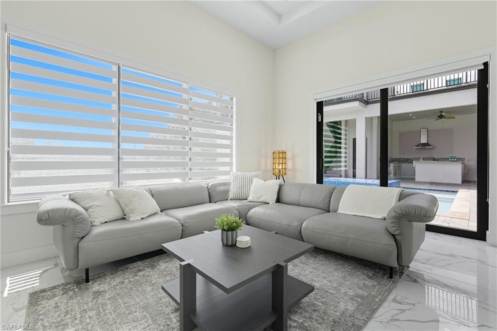 Living room with marble tiled flooring and a ceiling fan