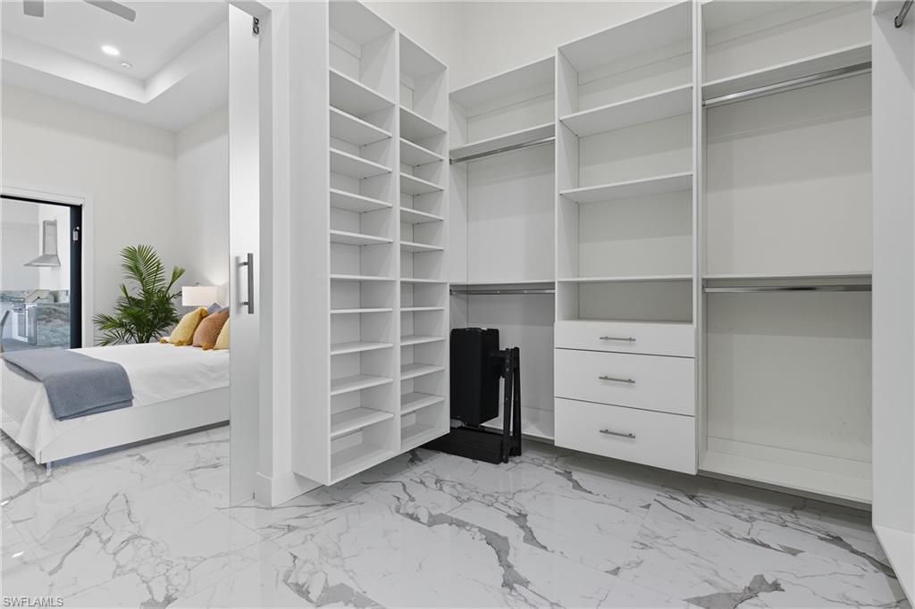 Spacious closet with light marble finish floors