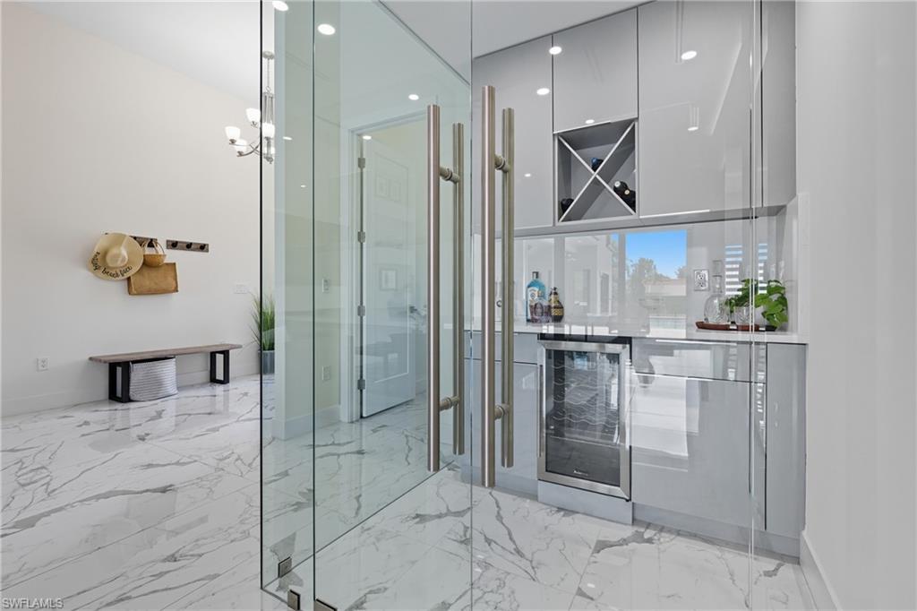 Corking Room with wine cooler, light marble finish floors, and recessed lighting