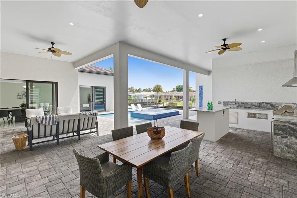 View of patio / terrace featuring ceiling fan, an outdoor pool, an outdoor kitchen, and outdoor dining space