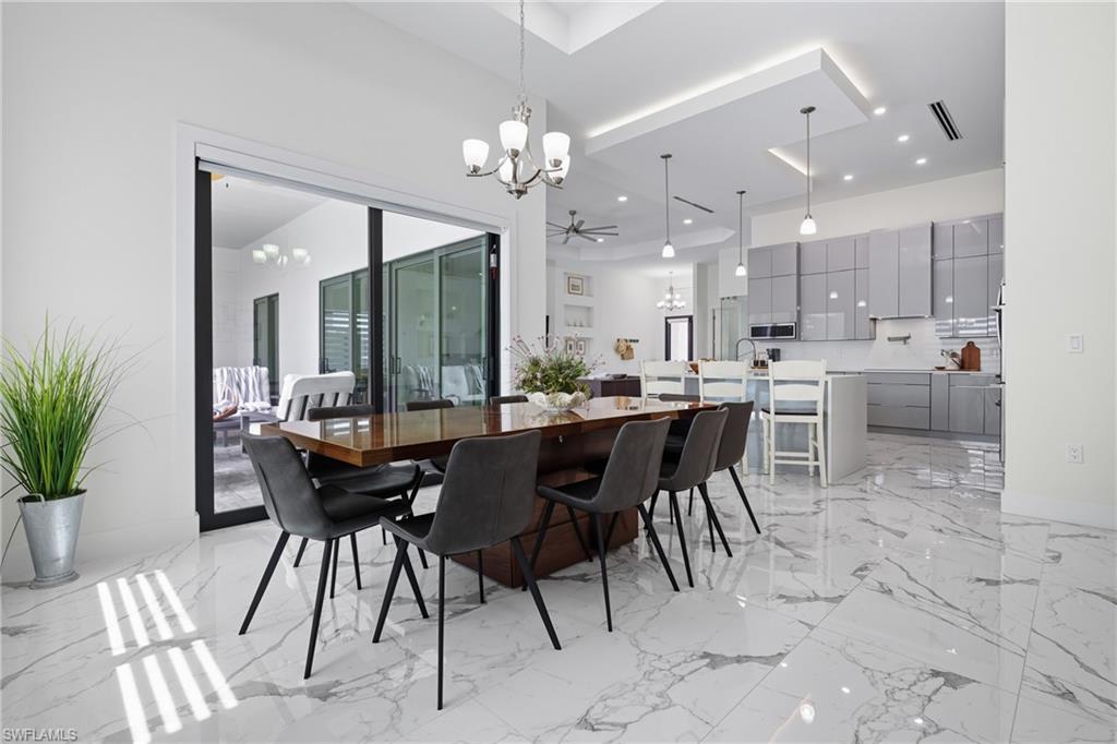 Dining area featuring a chandelier and light marble finish flooring