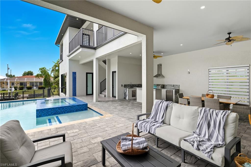 View of swimming pool featuring area for grilling, a patio, an outdoor hangout area, and a ceiling fan