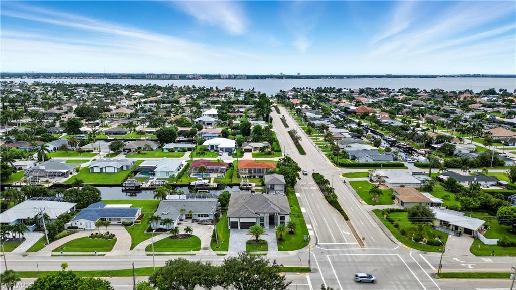 Aerial perspective of suburban area featuring a nearby body of water