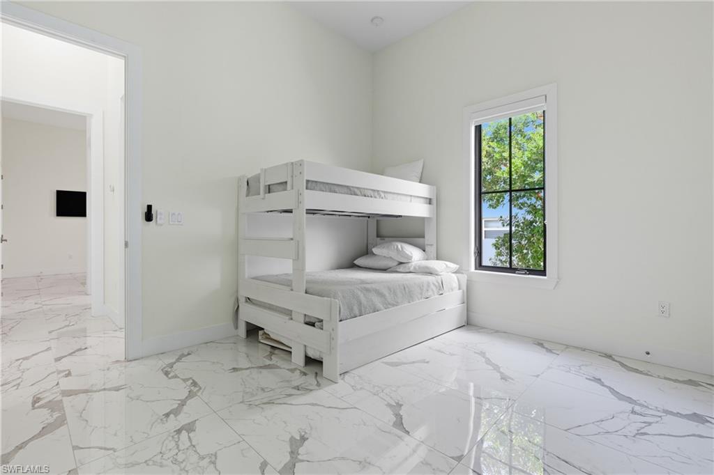 Bedroom with light marble finish floors and baseboards