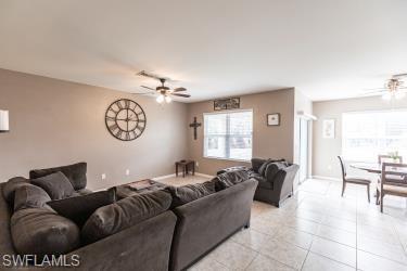 Living room with a ceiling fan and tile patterned flooring