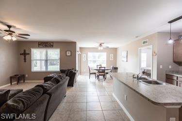 Living room with a ceiling fan and light tile patterned floors