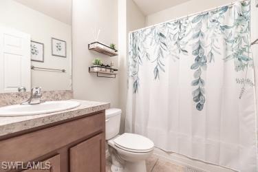 Full bath featuring vanity, shower / bath combo with shower curtain, and light tile patterned flooring