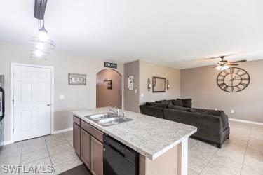 Kitchen with light countertops, pendant lighting, light tile patterned flooring, and open floor plan