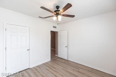 Unfurnished bedroom with light wood-style flooring, a ceiling fan, and a closet