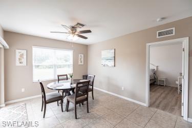 Dining room with ceiling fan and light tile patterned floors