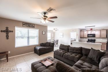 Living area with ceiling fan and light tile patterned floors