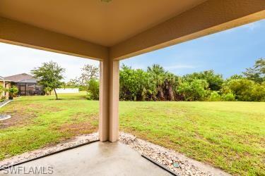 View of grassy yard featuring a patio area