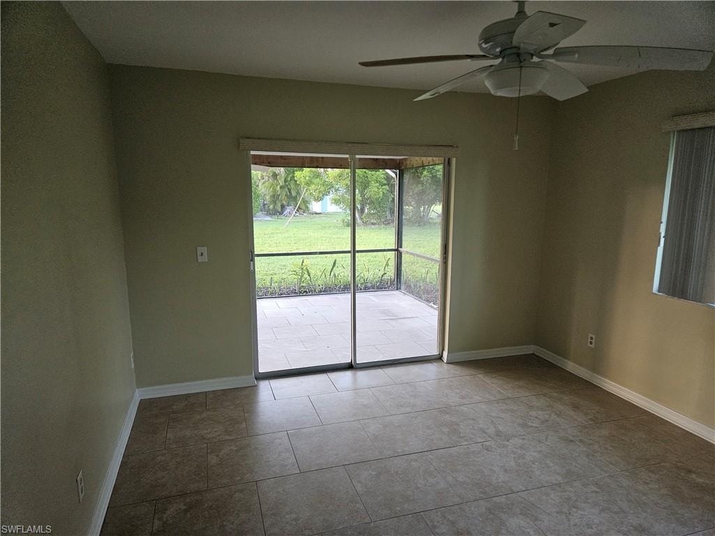 Unfurnished room featuring ceiling fan and tile patterned flooring