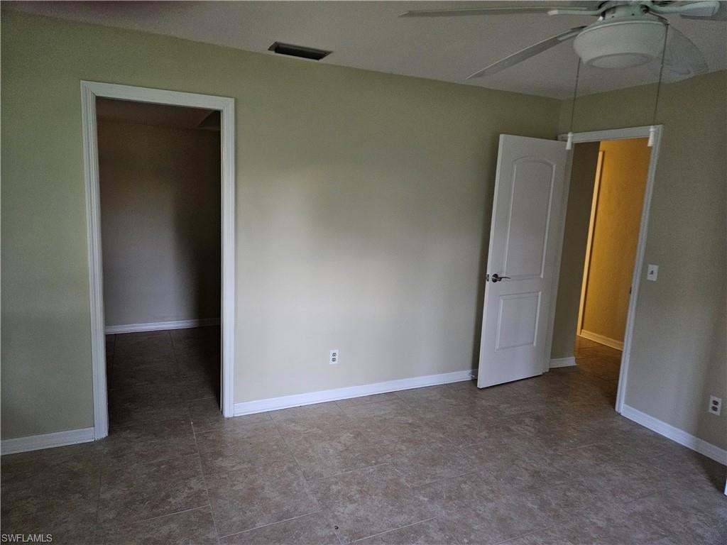 Unfurnished bedroom featuring a spacious closet and ceiling fan