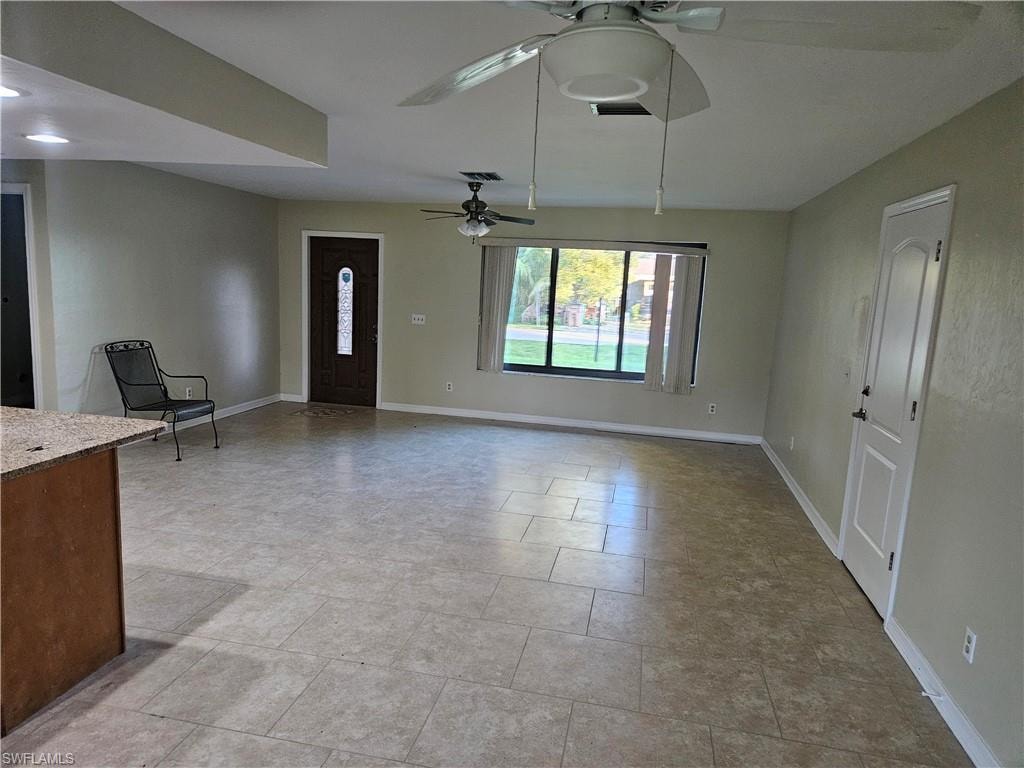 Unfurnished living room featuring baseboards