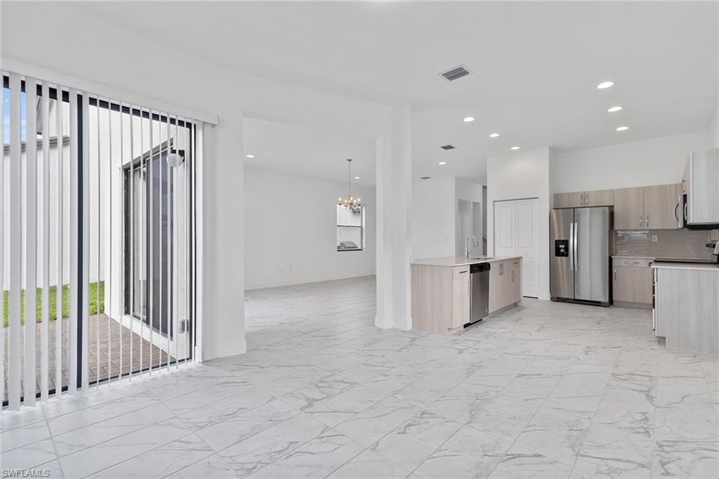 Kitchen featuring modern cabinets, open floor plan, stainless steel appliances, and recessed lighting