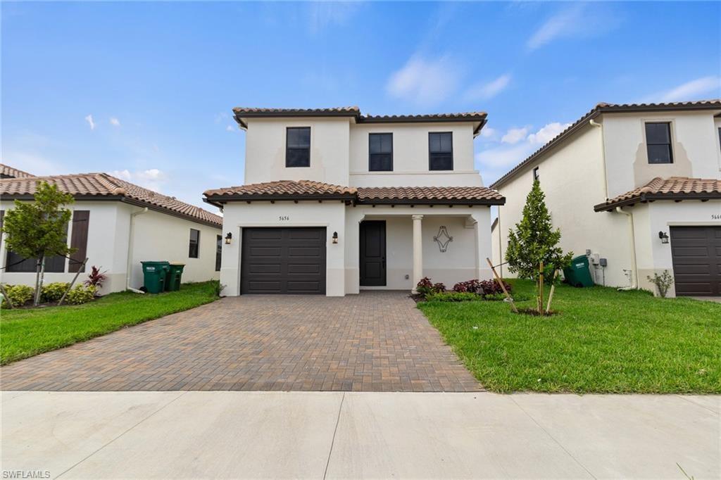 Mediterranean / spanish-style home with paved driveway, and a garage