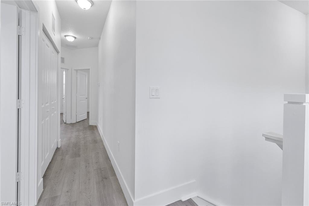 Upstairs hallway featuring wood-style flooring