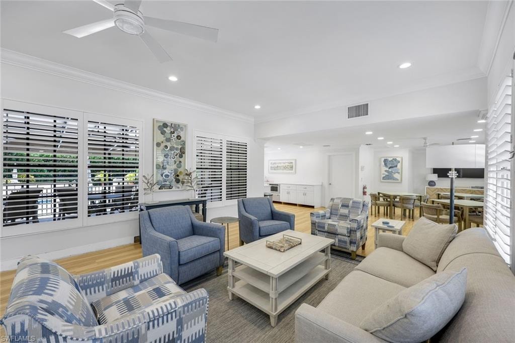 Living room featuring ornamental molding, wood finished floors, and recessed lighting