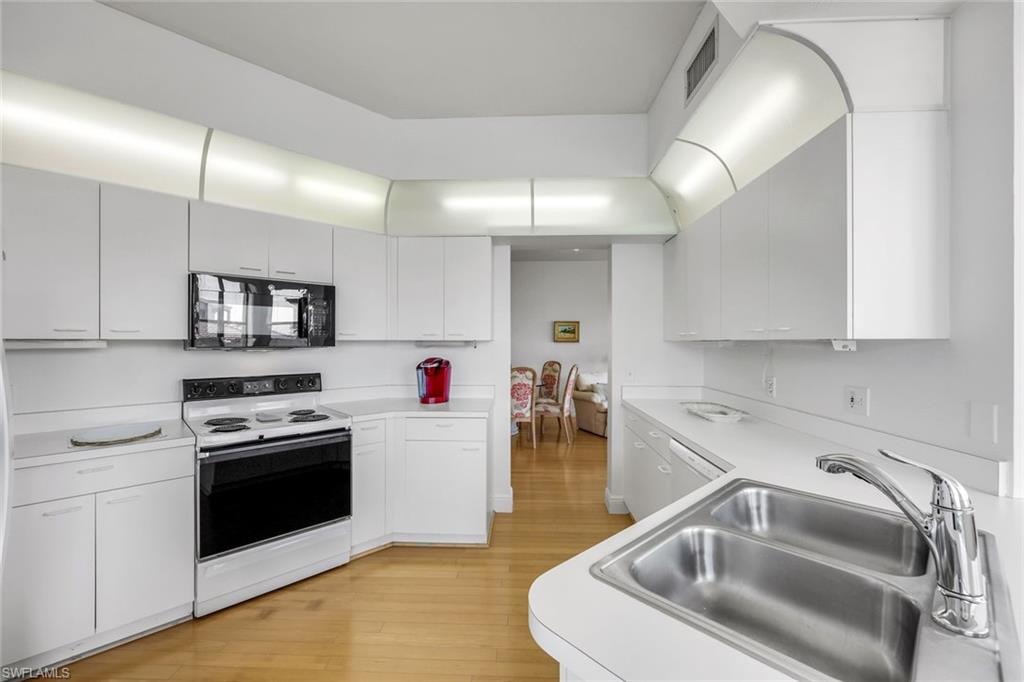 Kitchen featuring white appliances, light countertops, and light wood-type flooring
