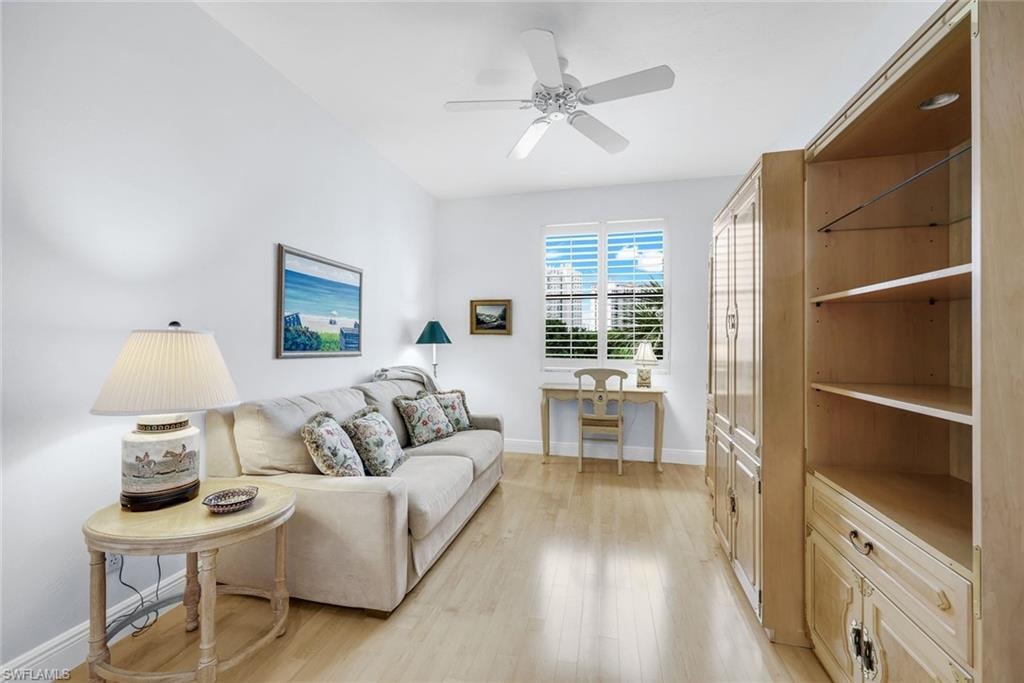 Living area with light wood finished floors and a ceiling fan