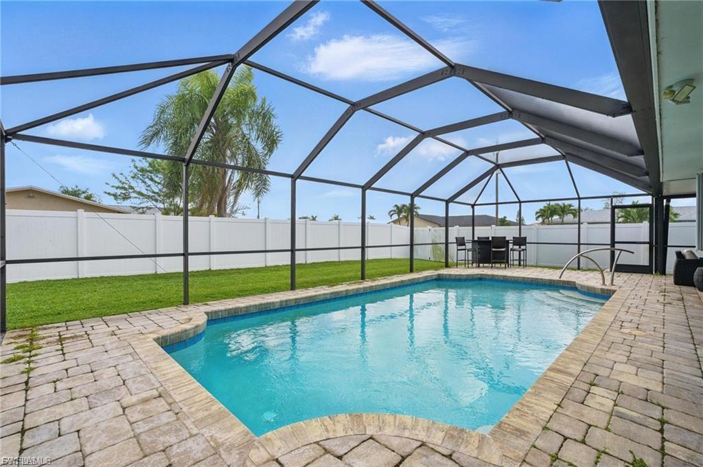 View of swimming pool featuring a sunroom, glass enclosure, a patio area, and a fenced backyard