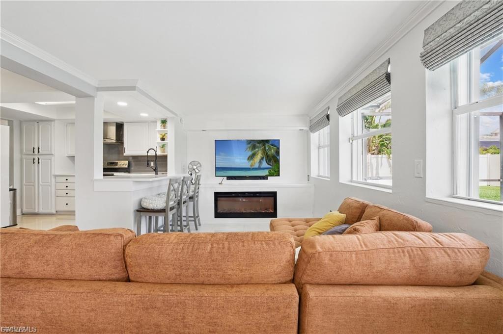 Living area with a glass covered fireplace and crown molding