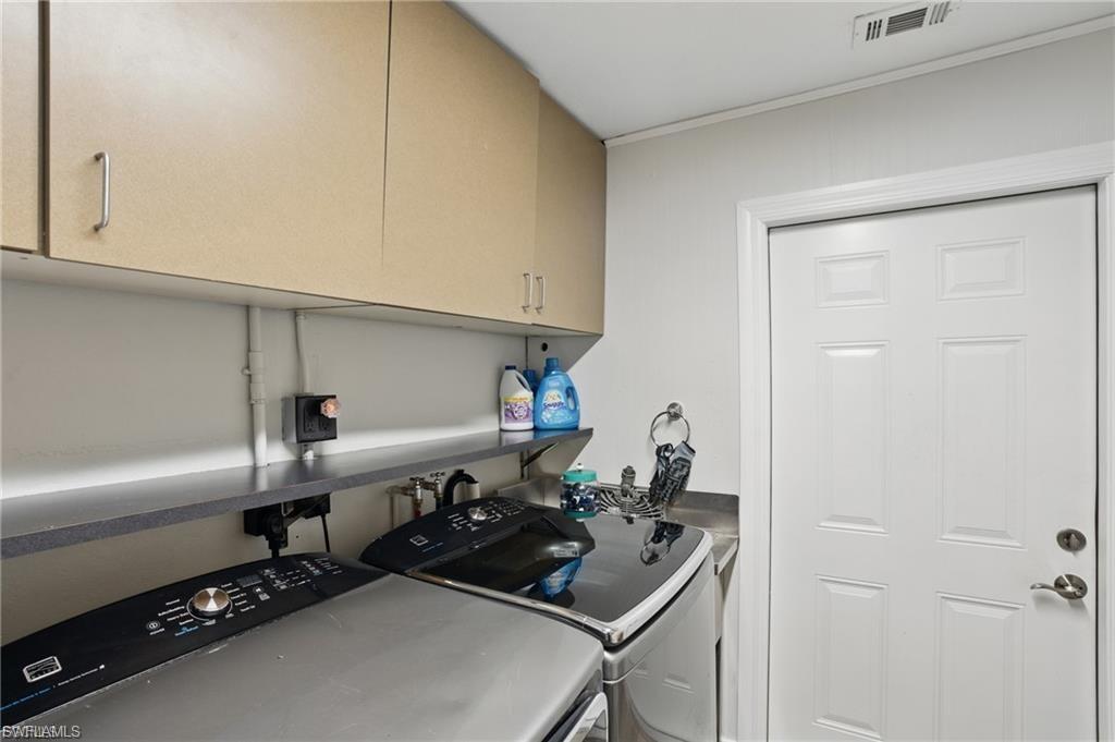Laundry room featuring washing machine and dryer and cabinet space