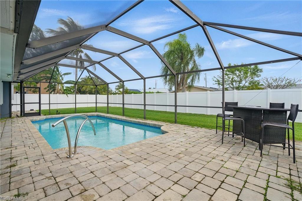 View of pool with a sunroom, glass enclosure, a patio, and a fenced backyard