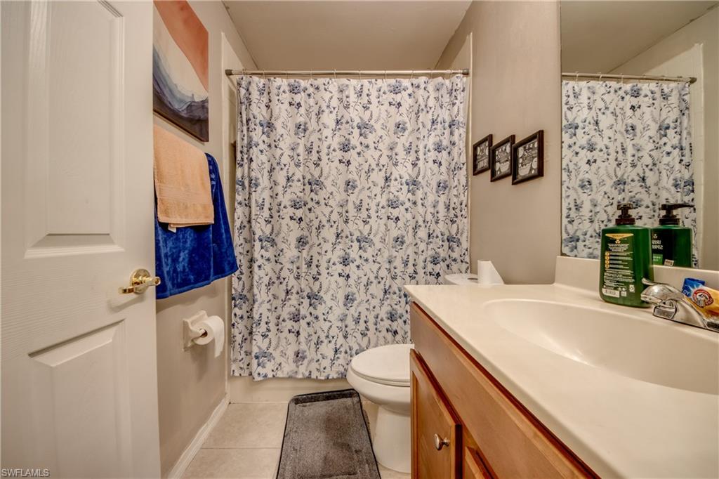Bathroom featuring vanity, light tile patterned flooring, and a shower with shower curtain