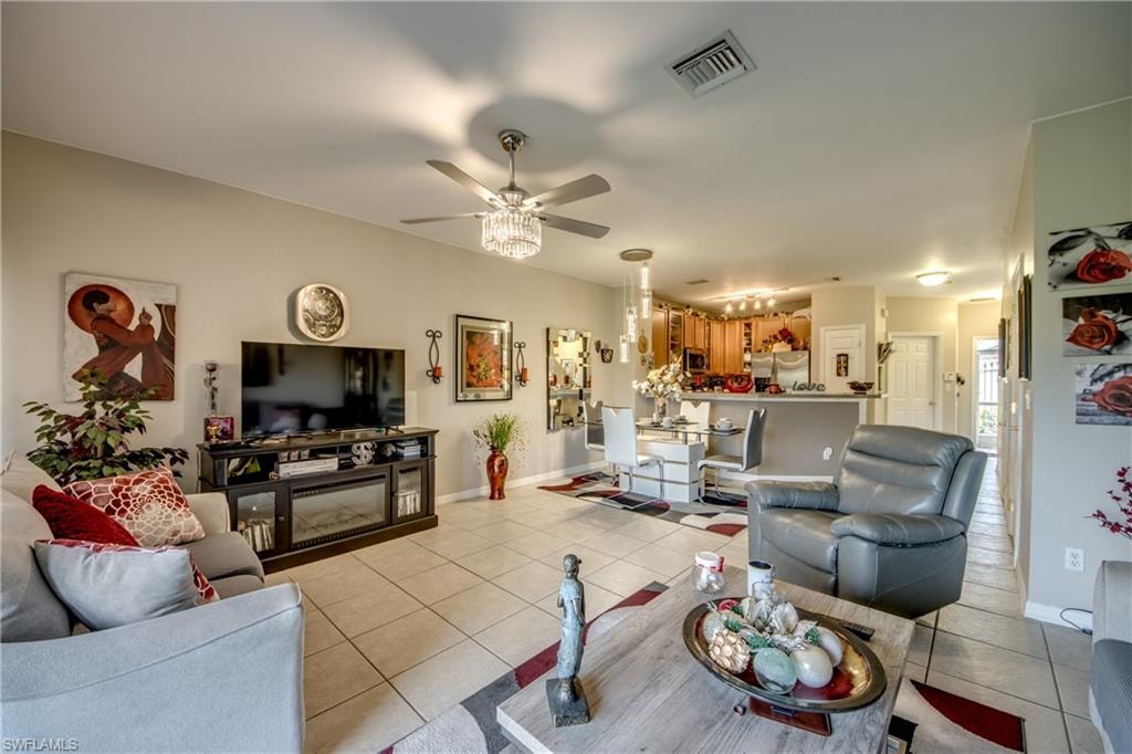 Living room featuring light tile patterned floors and a ceiling fan