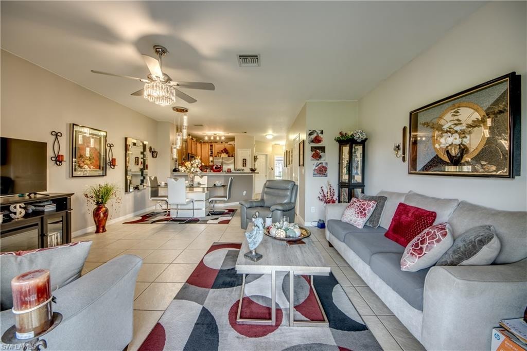 Living room with light tile patterned floors and a ceiling fan