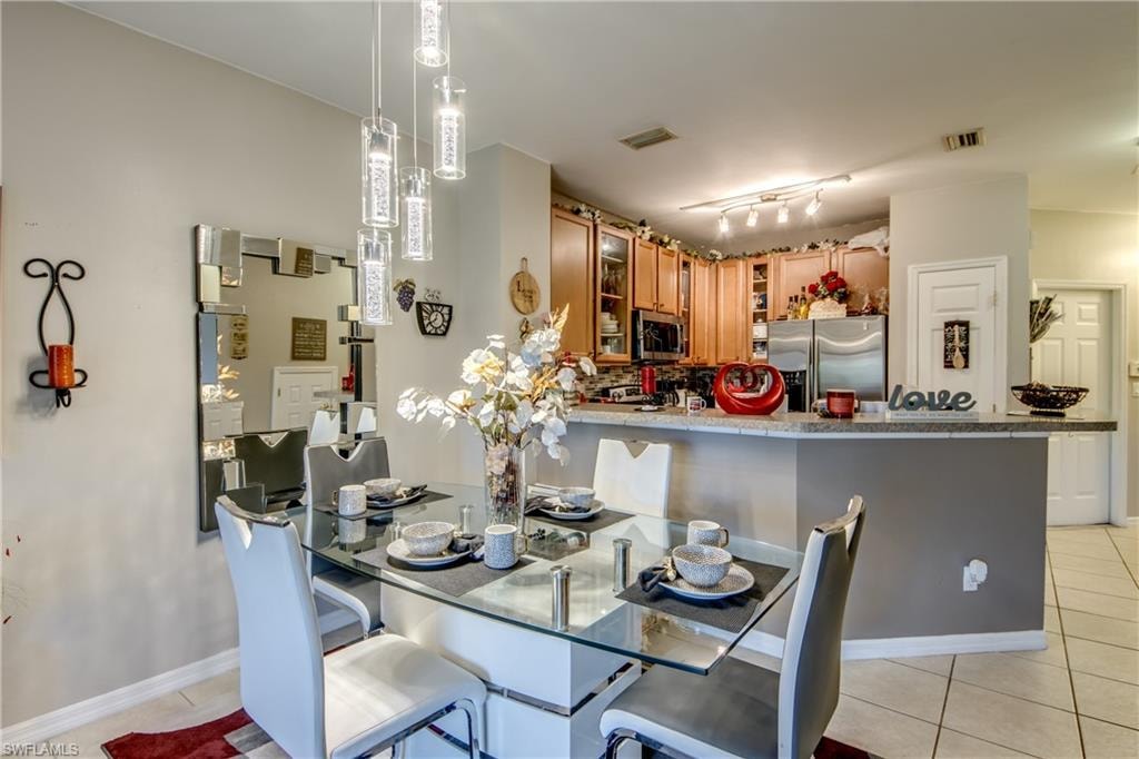 Dining area featuring light tile patterned floors and rail lighting