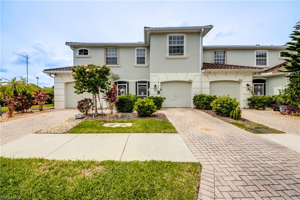 View of front of house with decorative driveway and stucco siding