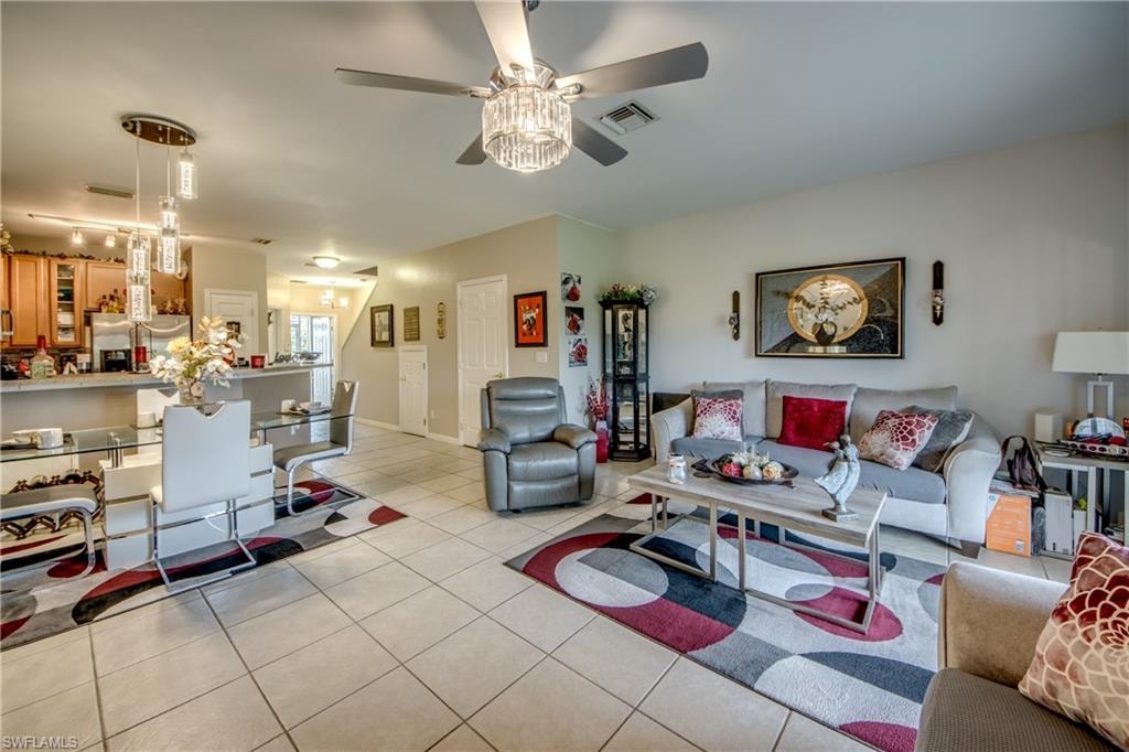 Living area featuring light tile patterned flooring and ceiling fan