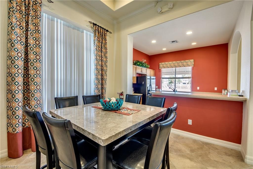 Clubhouse with light tile patterned floors, crown molding, and recessed lighting