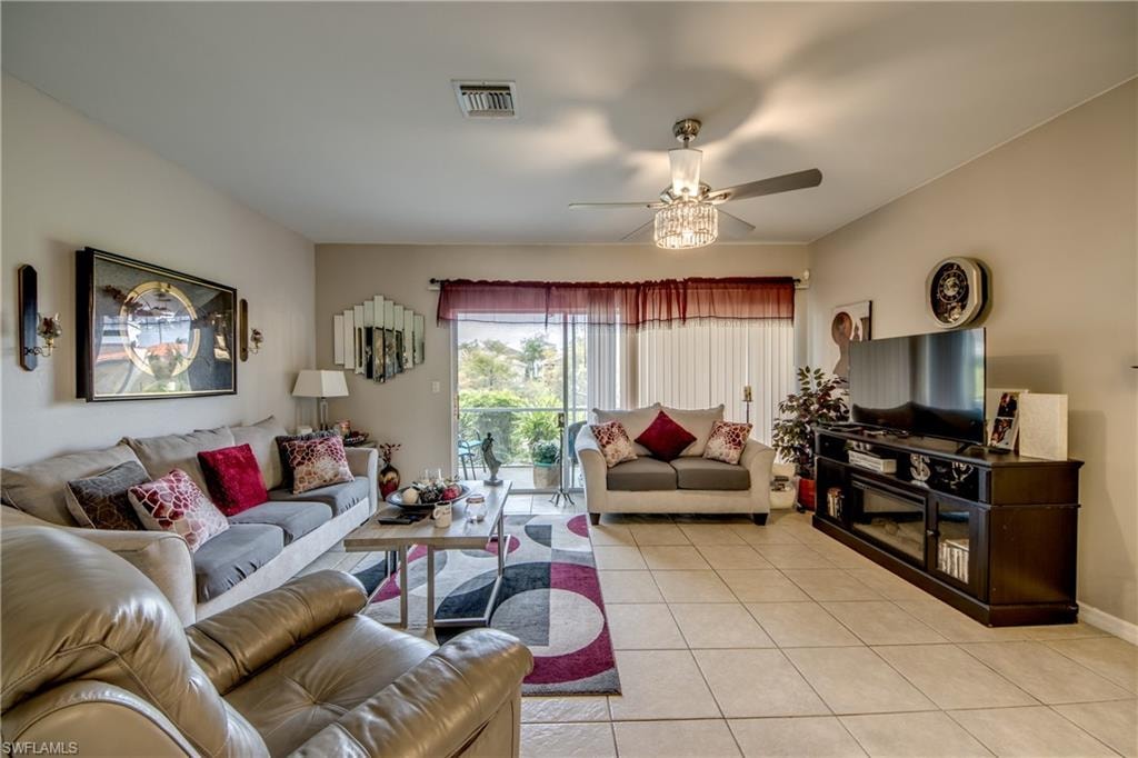 Living room featuring light tile patterned flooring and a ceiling fan
