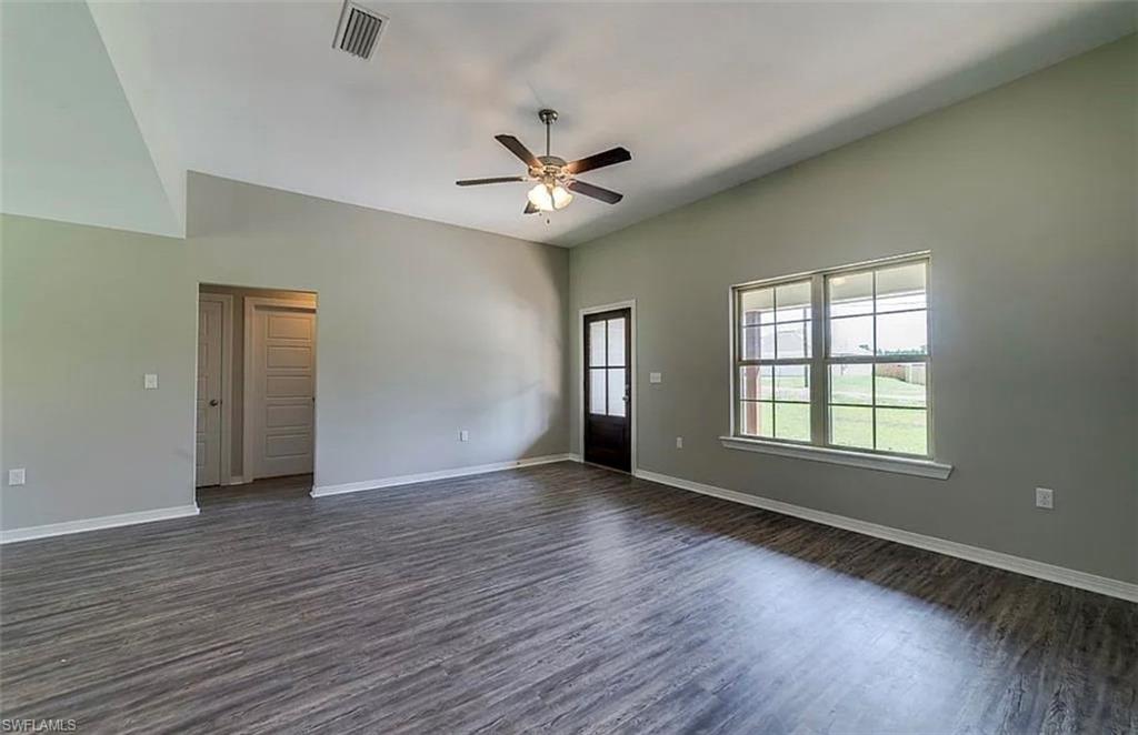 Spare room featuring dark wood-style flooring and ceiling fan