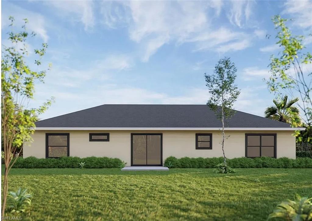 View of front facade featuring a front yard and stucco siding