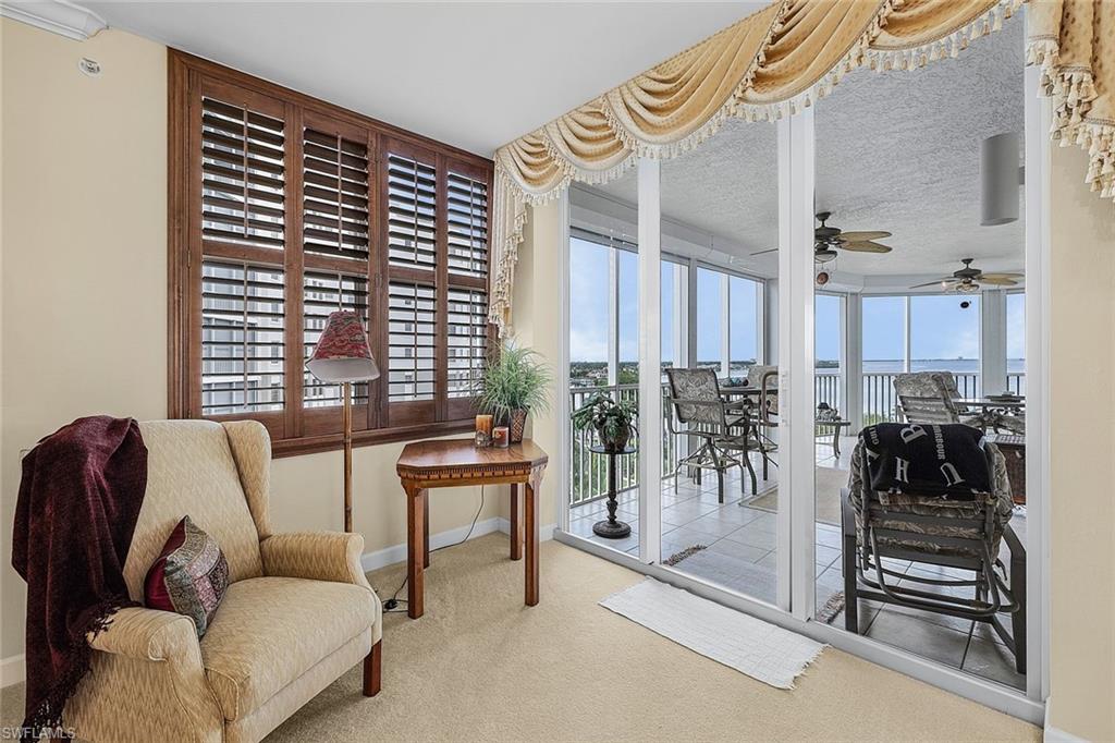 Living area with carpet floors, ceiling fan, and a water view
