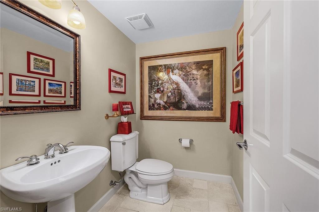 Half bath featuring toilet and light tile patterned flooring