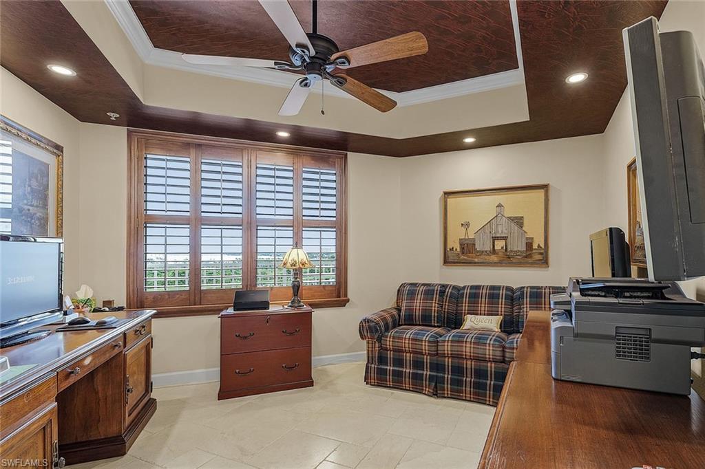 Office space with a tray ceiling, ornamental molding, recessed lighting, a ceiling fan, and light tile patterned floors