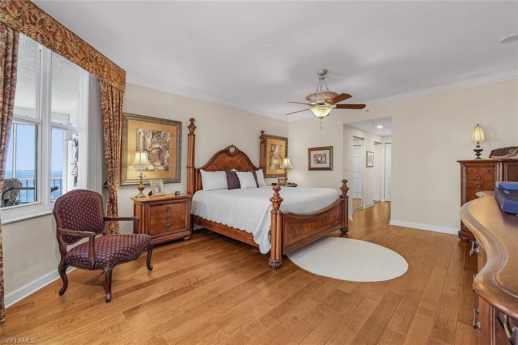 Bedroom featuring ornamental molding, light wood-style floors, and ceiling fan