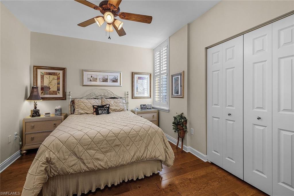 Bedroom with dark wood-style flooring, a closet, and a ceiling fan
