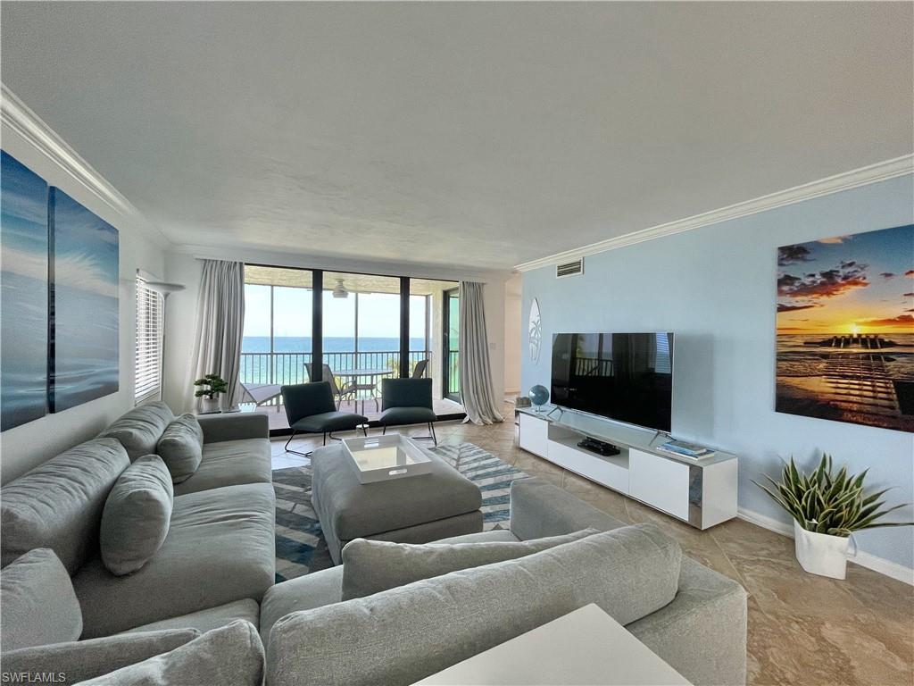 Living area with crown molding and a wall of windows