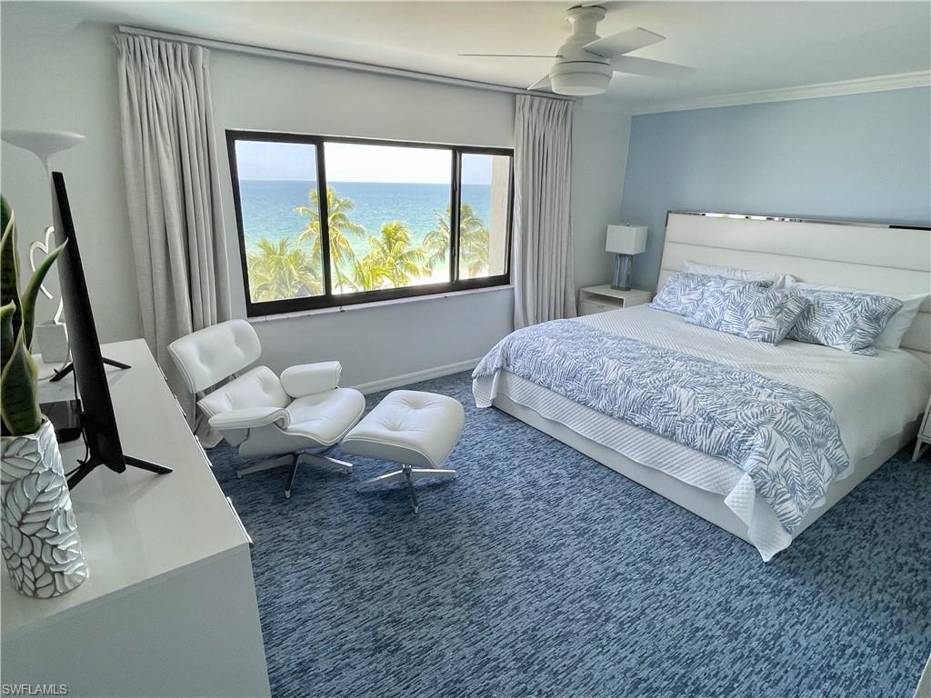 Carpeted bedroom featuring a ceiling fan and a water view