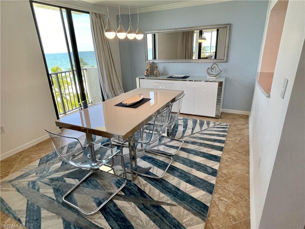 Dining area with ornamental molding and a water view
