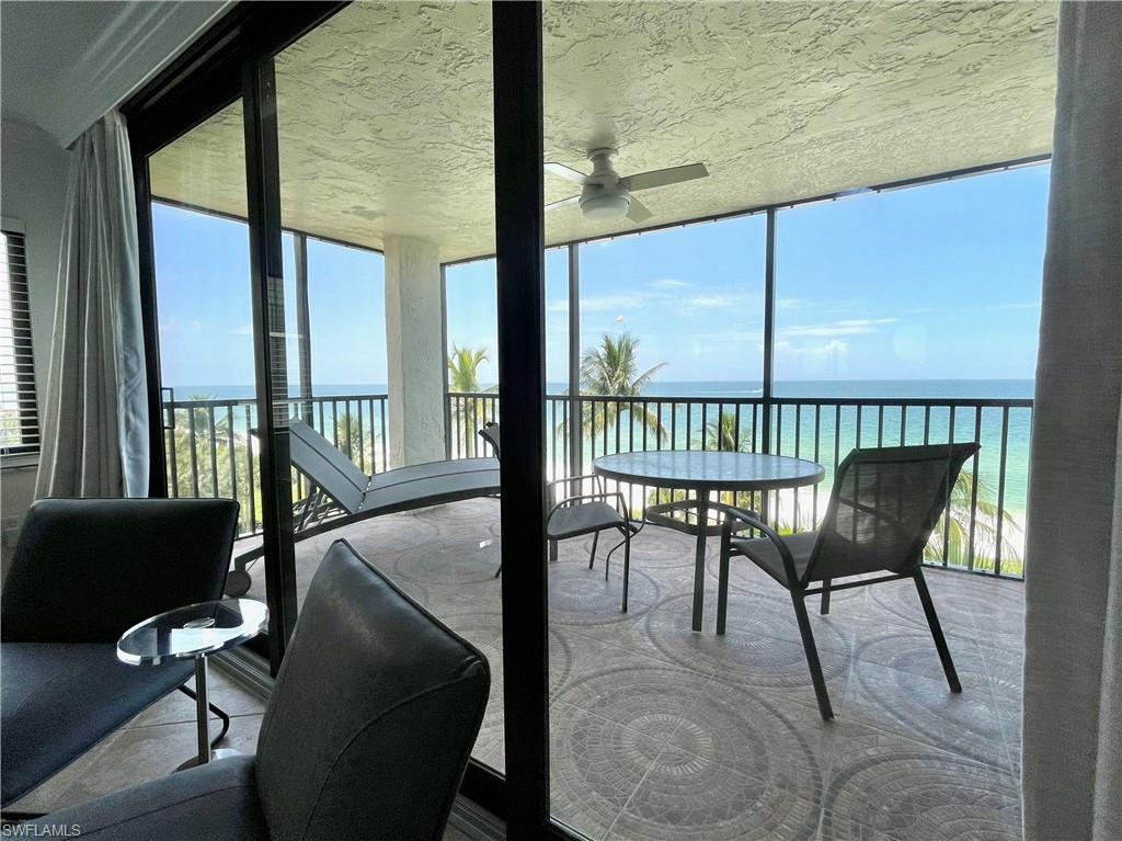 Sunroom with a water view and a wall of windows