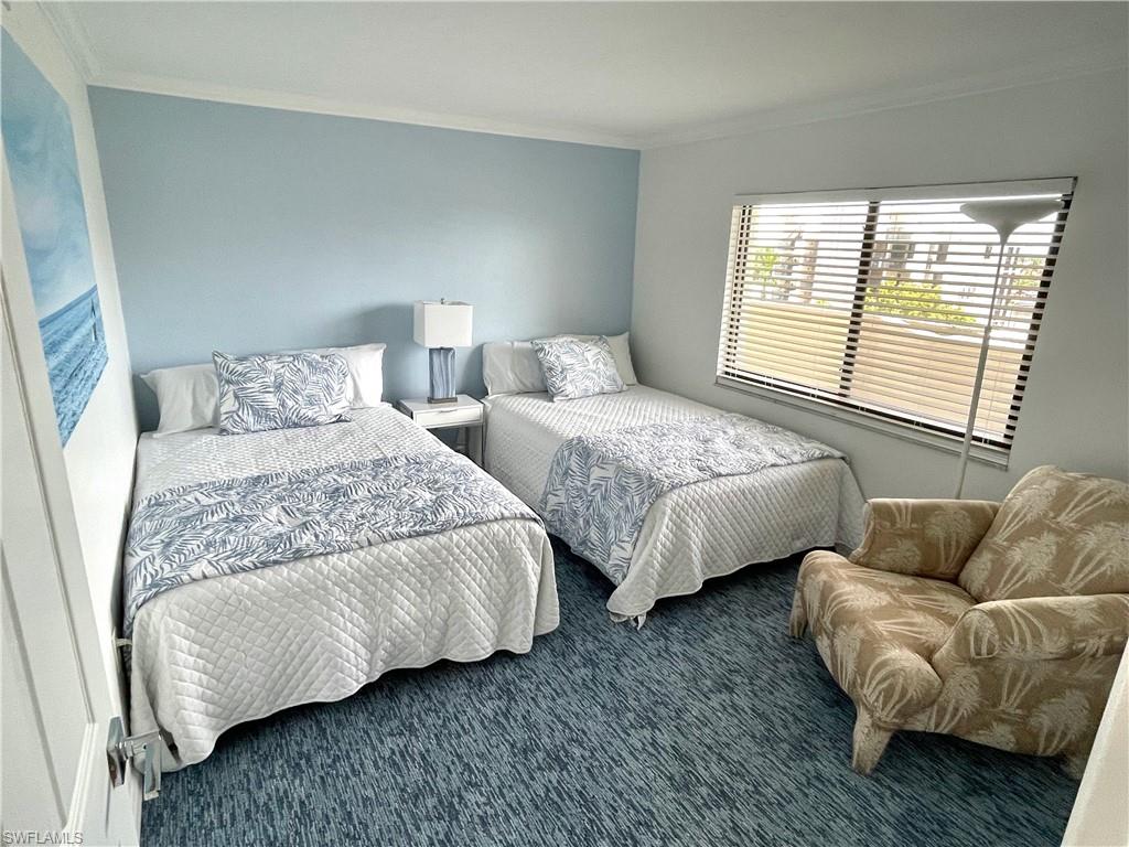 Carpeted bedroom with ornamental molding