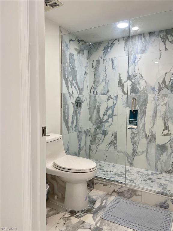 Full bathroom featuring marble finish floors and a marble finish shower